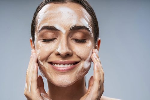 Happy Caucasian lady taking care of facial skin. Beauty procedures concept